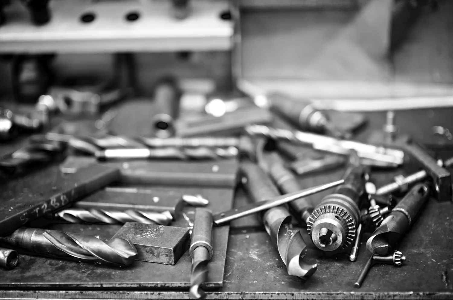 Drill bits and metalworking equipment on a workshop bench