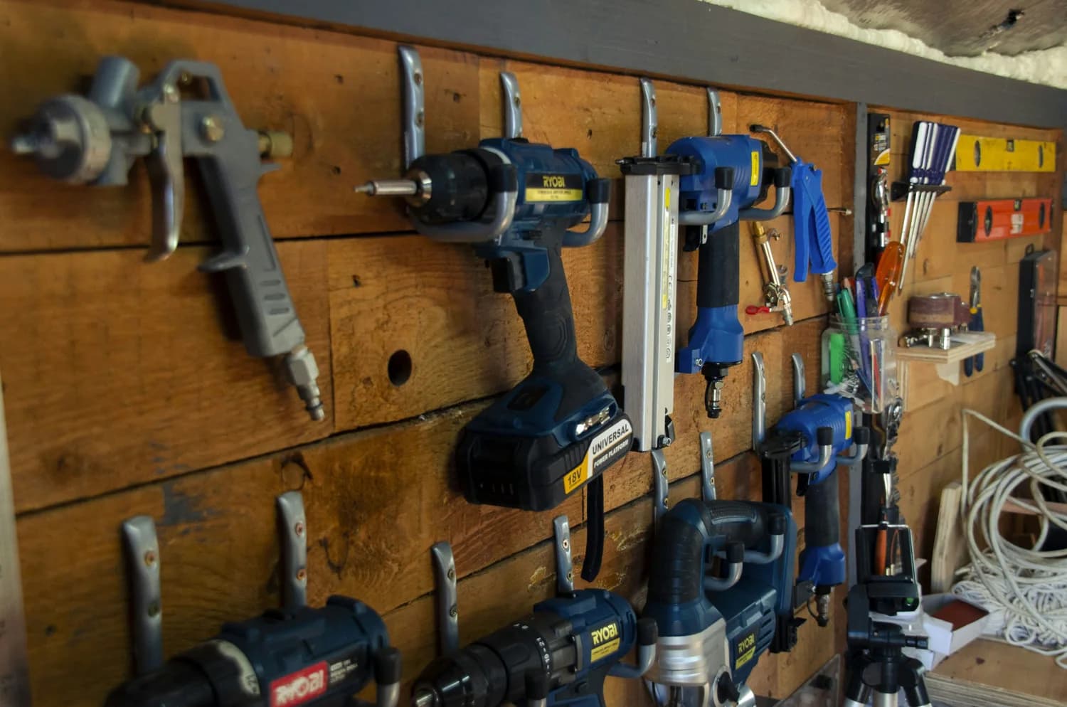 Power tools neatly arranged on a workshop wall